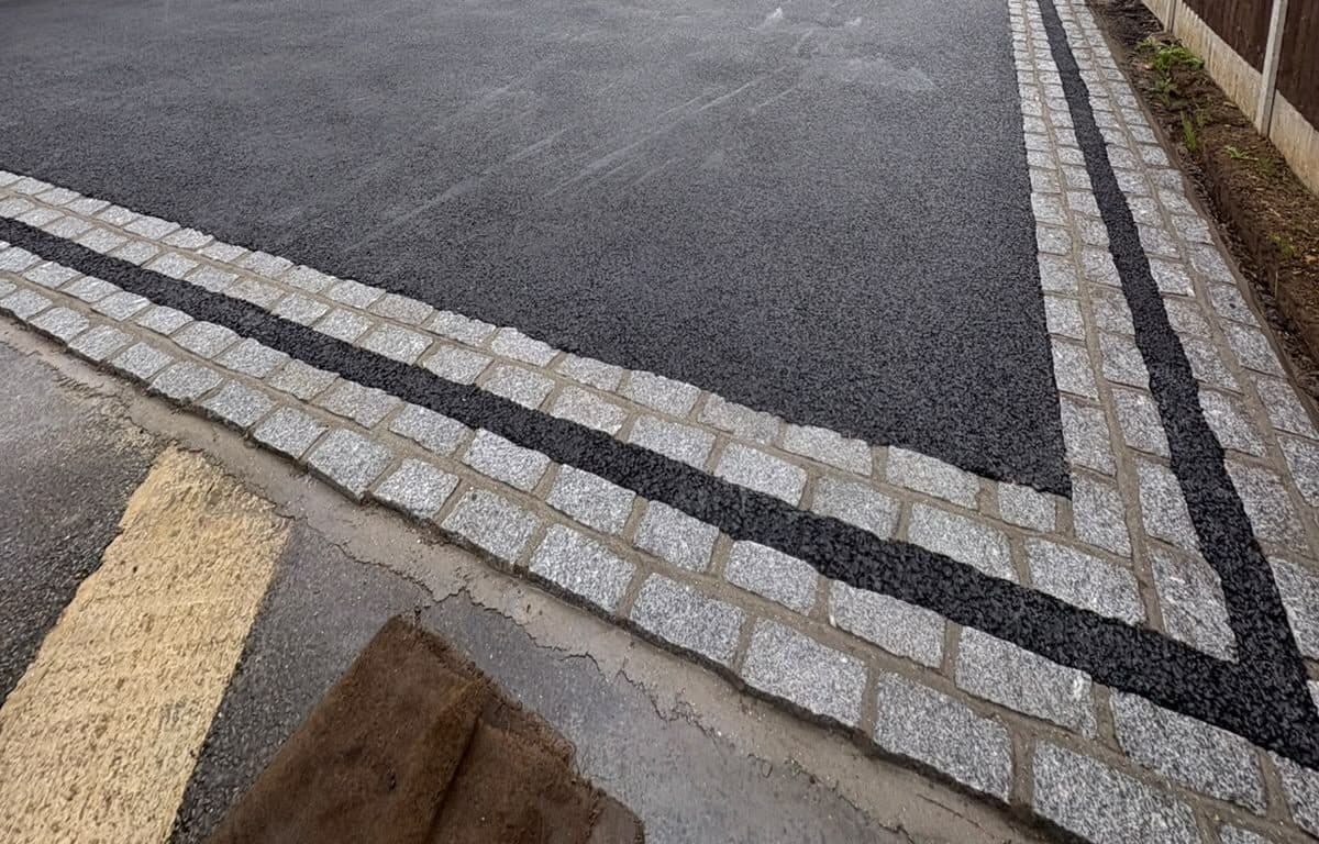 Close view of fresh tarmac with a double-stripe granite sett border